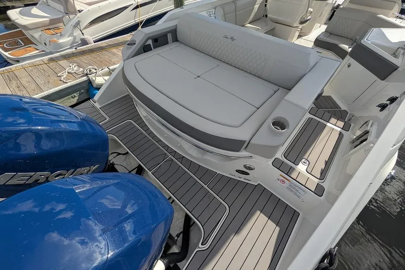 Slide: The Image of 2023 Sea Ray 310 SLX boat with twin Mercury 400 engines, docked by the water. - 3