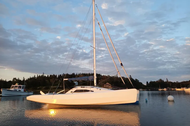 The Image of Sleek 2007 Scarab 22 sailboat anchored in tranquil waters at sunset. - 0