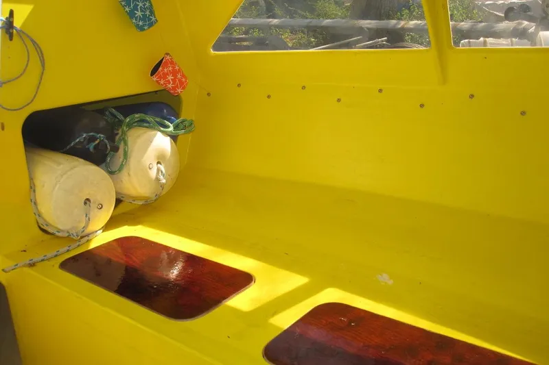 Slide: The Image of Yellow interior of 2007 Scarab 22 boat with storage and colorful accessories. - 11