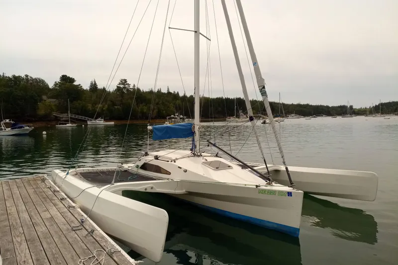 Slide: The Image of 2007 Scarab 22 trimaran docked in a serene marina setting. - 2