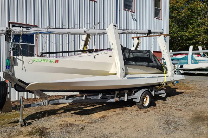 Slide: The Image of 2007 Scarab 22 sailboat on trailer, parked beside a metal building. - 5