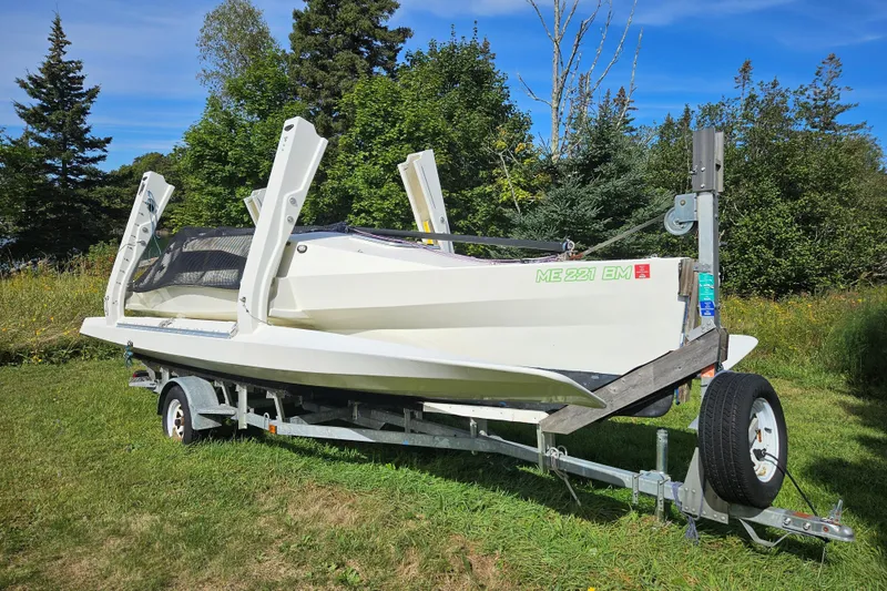 Slide: The Image of 2007 Scarab 22 boat on trailer, surrounded by lush greenery and clear blue sky. - 6