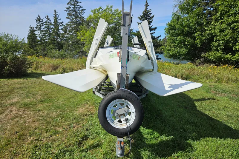 Slide: The Image of 2007 Scarab 22 boat on trailer, surrounded by lush greenery and trees. - 8