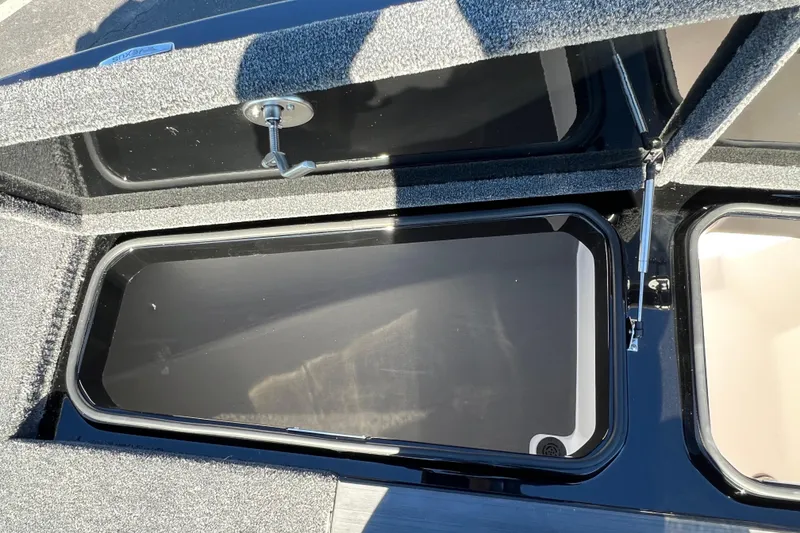 Slide: The Image of 2026 Vexus DVX20S boat storage compartment with open lid and carpeted interior. - 7