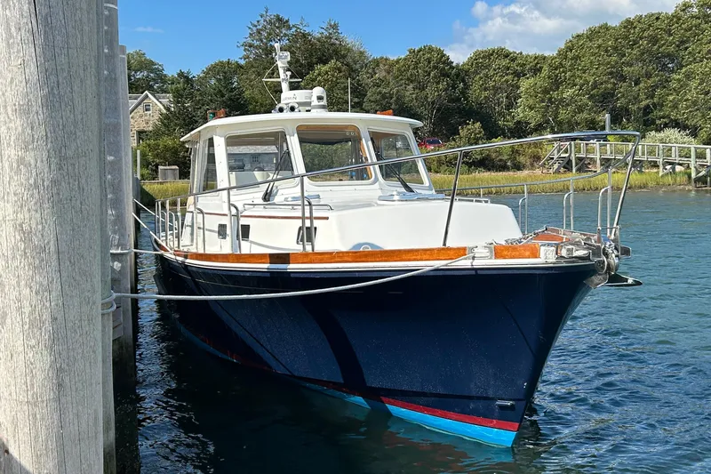 The Image of Classic 1999 Eastbay 38 boat docked in a serene marina setting. - 0
