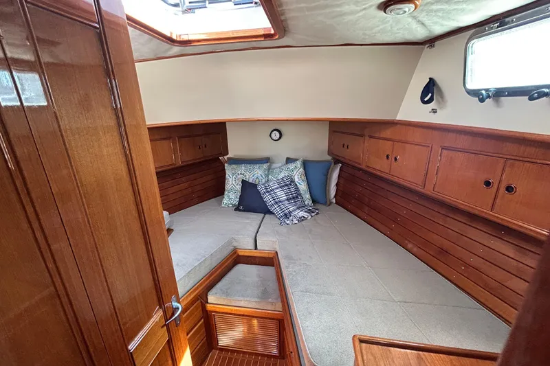 Slide: The Image of 1999 Eastbay 38 yacht cabin with wooden interior and cozy bedding. - 11