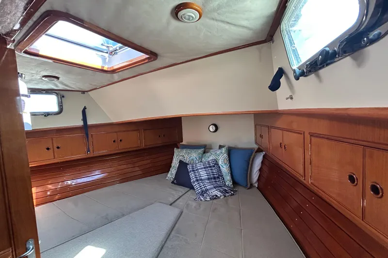 Slide: The Image of Cozy cabin interior of 1999 Eastbay 38 boat with wooden finish and cushions. - 12