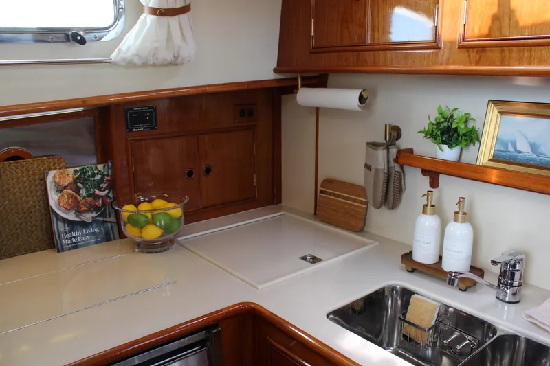 Slide: The Image of Luxurious 1999 Grand Banks 38 Eastbay HX yacht kitchen with elegant wood cabinetry and modern amenities. - 18