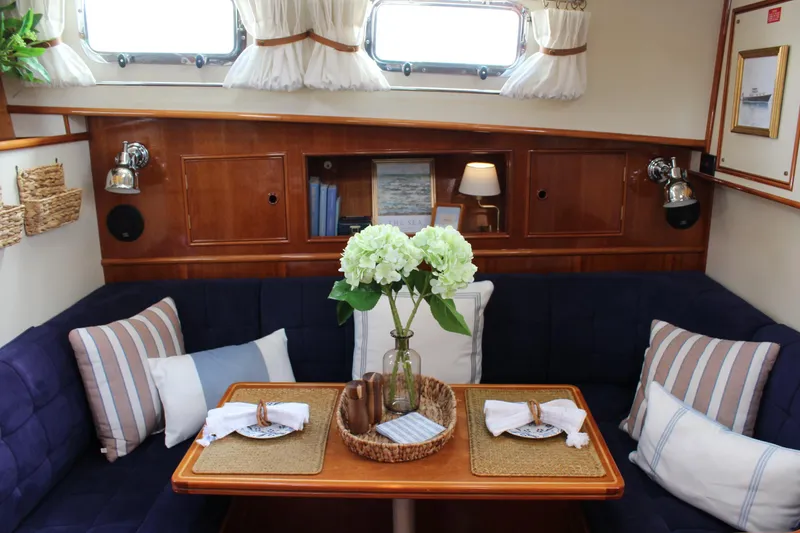 Slide: The Image of Cozy interior of 1999 Grand Banks 38 Eastbay HX with elegant dining setup and floral centerpiece. - 19