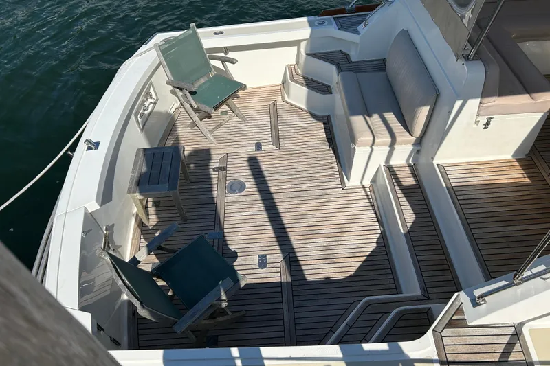 Slide: The Image of 1999 Eastbay 38 boat deck with wooden flooring, chairs, and seating area. - 2