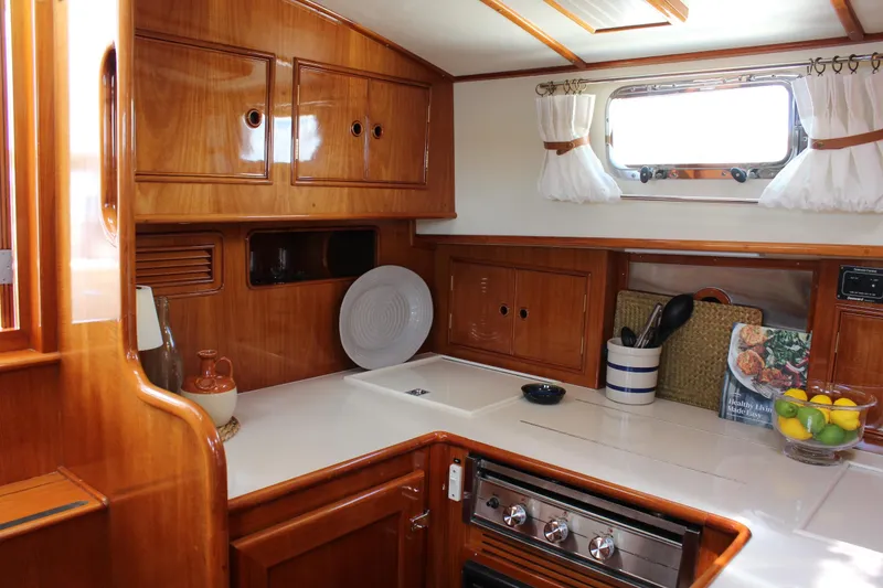Slide: The Image of Luxurious 1999 Grand Banks 38 Eastbay HX yacht kitchen with wooden cabinetry and modern amenities. - 22