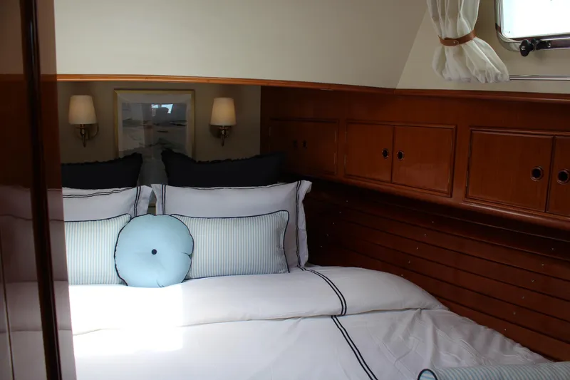 Slide: The Image of Cozy cabin interior of 1999 Grand Banks 38 Eastbay HX with elegant bedding and wooden cabinetry. - 23