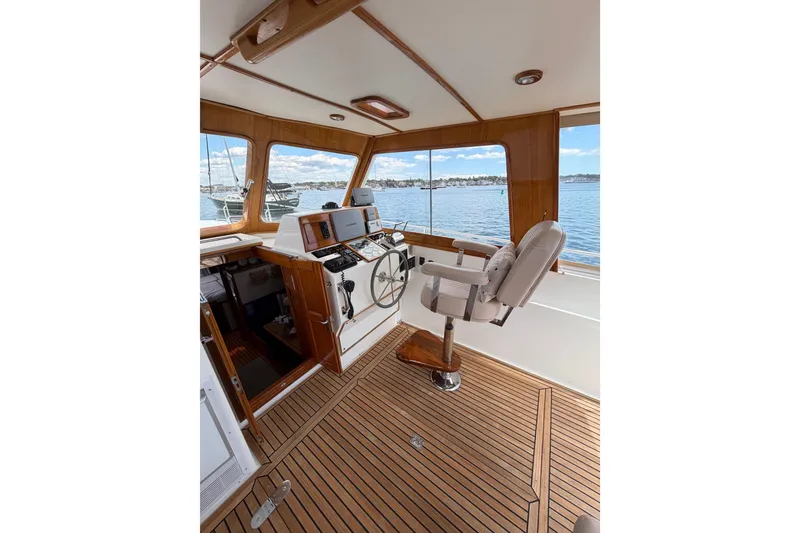 Slide: The Image of Helm of 1999 Grand Banks 38 Eastbay HX yacht with wooden interior and waterfront view. - 32