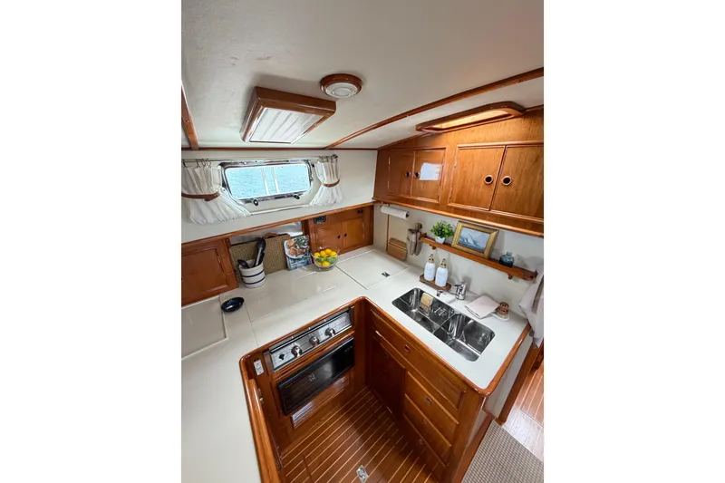 Slide: The Image of Interior of 1999 Grand Banks 38 Eastbay HX yacht, featuring a well-equipped kitchen area. - 34