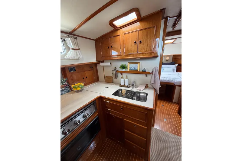 Slide: The Image of Luxurious 1999 Grand Banks 38 Eastbay HX yacht interior with elegant wooden cabinetry and modern amenities. - 36