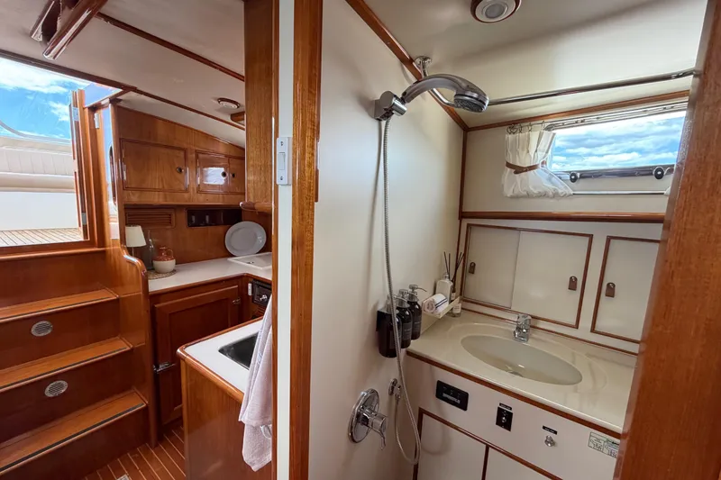 Slide: The Image of Interior of 1999 Grand Banks 38 Eastbay HX yacht, featuring a compact bathroom and kitchenette. - 42