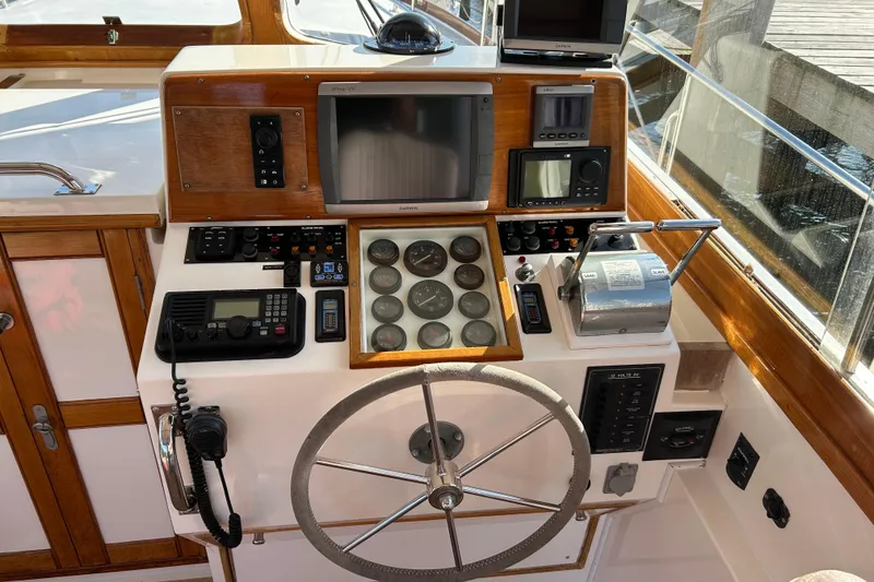 Slide: The Image of Control panel of a 1999 Eastbay 38 boat with navigation instruments and steering wheel. - 6
