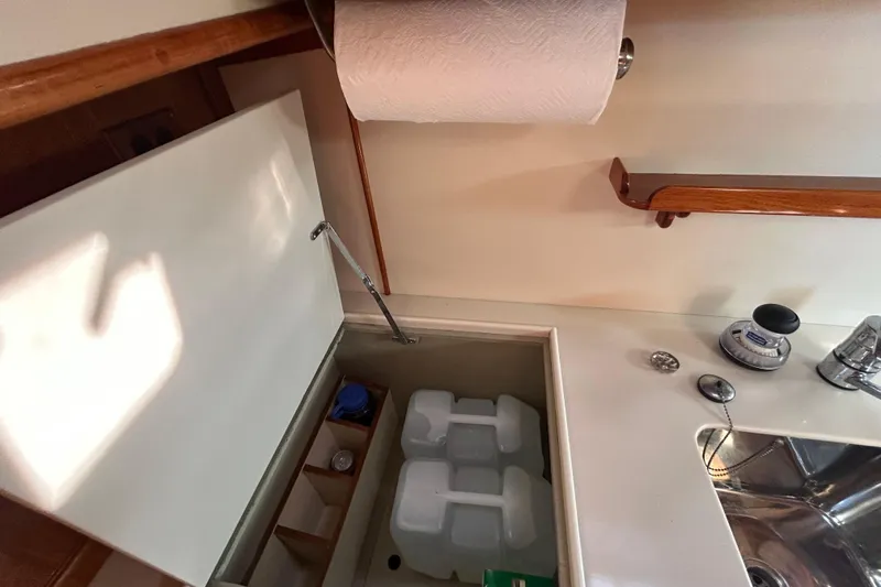 Slide: The Image of Interior of 1999 Eastbay 38 boat kitchen with sink, storage, and paper towel holder. - 9