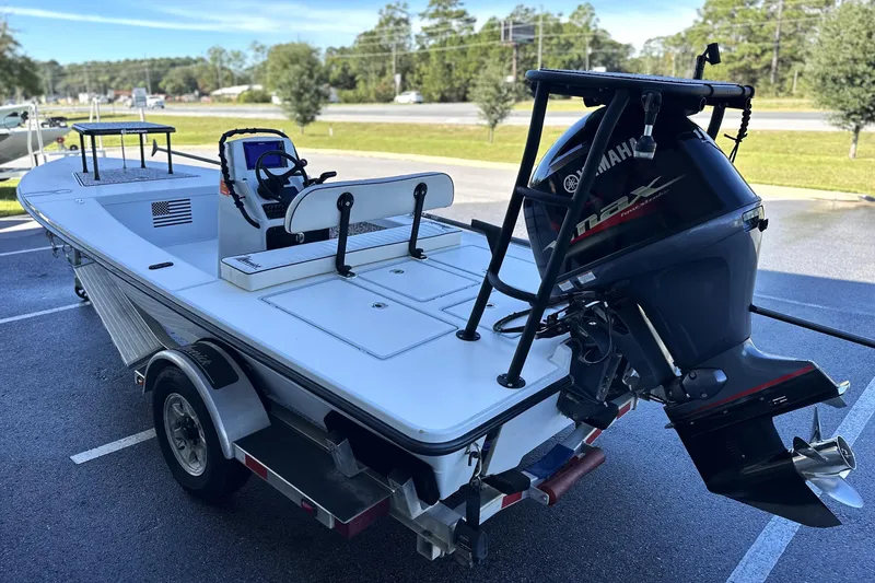 Slide: The Image of 2021 Maverick 18 HPX-V boat with Yamaha engine on a trailer in a parking lot. - 2