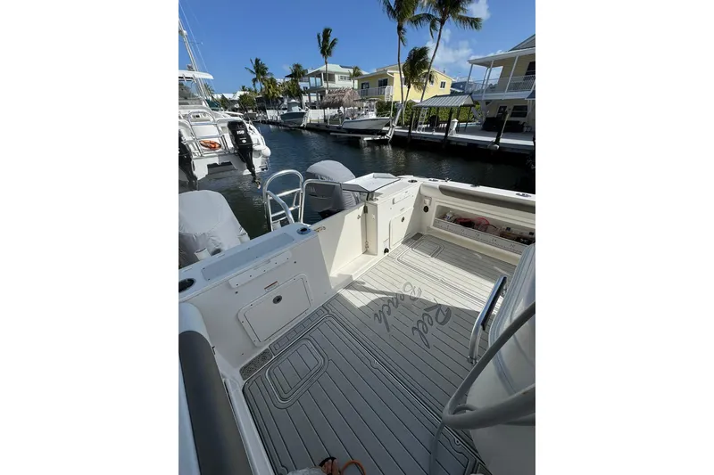Slide: The Image of 2019 World Cat 295 CC boat docked in a sunny marina with palm trees. - 16