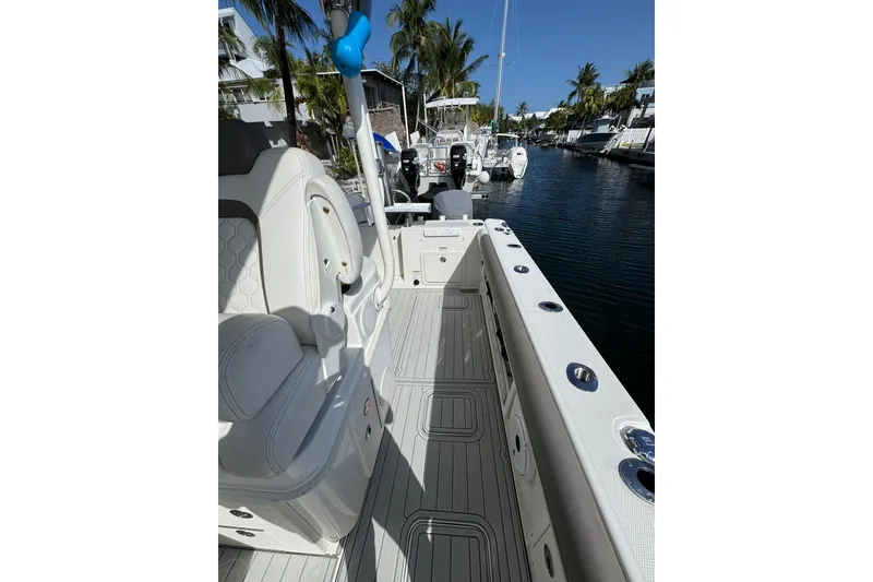 Slide: The Image of 2019 World Cat 295 CC boat interior with seating, docked in a sunny marina. - 18