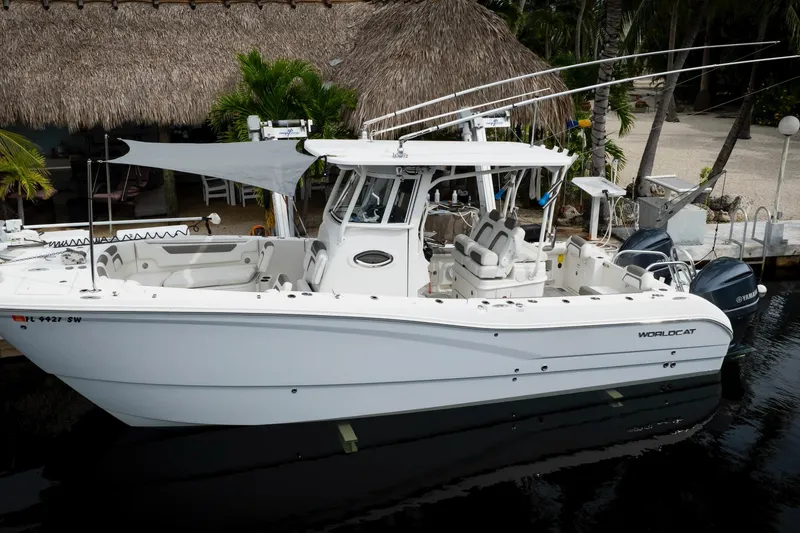 Slide: The Image of 2021 World Cat 295 CC boat docked, featuring dual engines and spacious seating. - 2