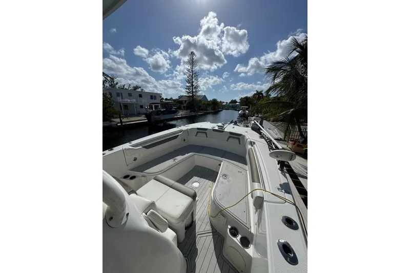 Slide: The Image of 2019 World Cat 295 CC boat docked under a sunny sky with palm trees. - 20