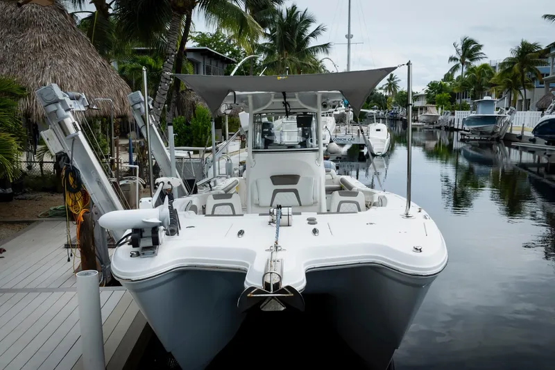 Slide: The Image of 2021 World Cat 295 CC boat docked in a tropical marina setting. - 4