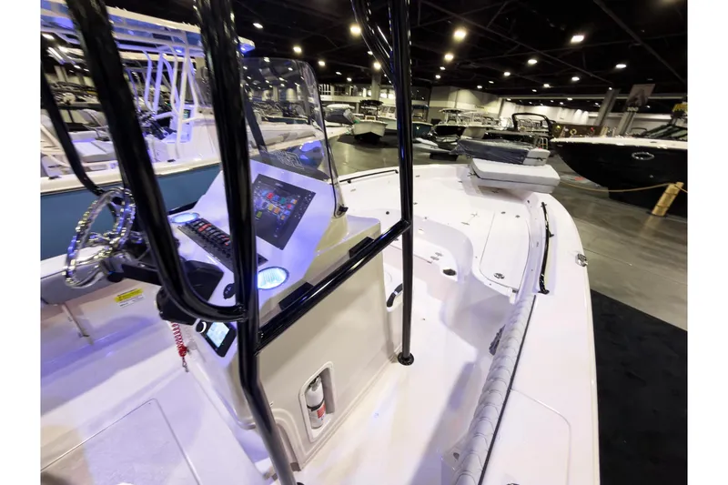 Slide: The Image of 2026 Sea Chaser 23 LX boat interior at a showroom, featuring modern controls and seating. - 15