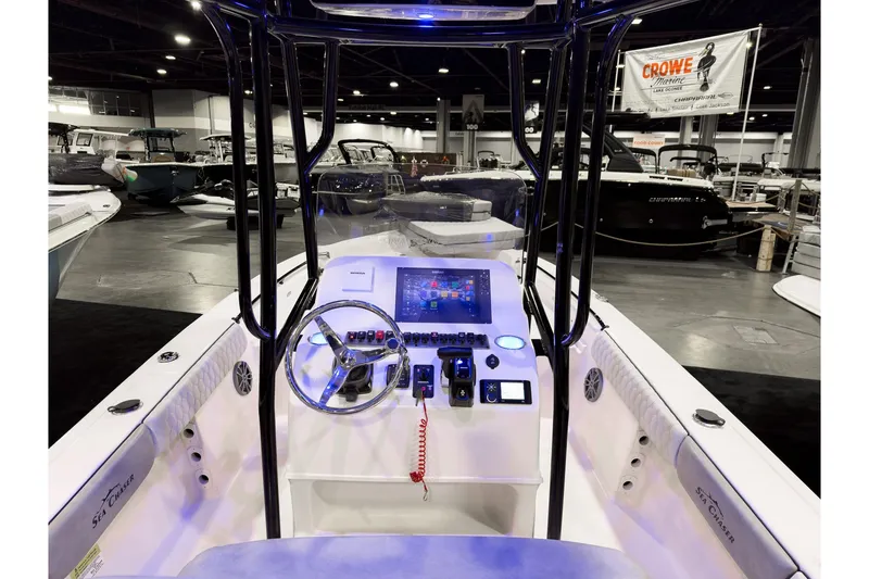 Slide: The Image of 2026 Sea Chaser 23 LX boat interior with modern dashboard and steering wheel at a boat show. - 4