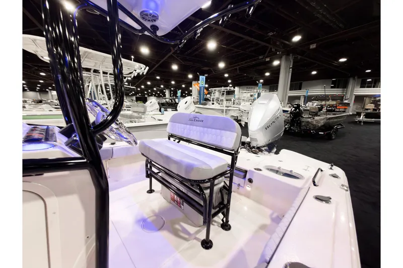 Slide: The Image of 2026 Sea Chaser 23 LX boat interior at a showroom, featuring seating and engine. - 8