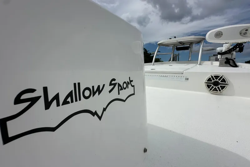 Slide: The Image of 2020 Shallow Sport 24 Classic boat with logo, under cloudy sky. - 12