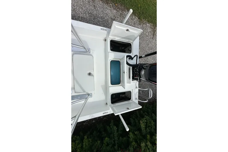 Slide: The Image of 2020 Shallow Sport 24 Classic boat deck with open storage compartments and motor. - 17