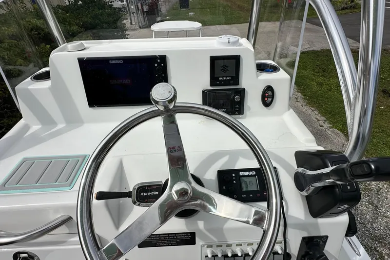 Slide: The Image of 2020 Shallow Sport 24 Classic boat dashboard with steering wheel and navigation controls. - 6