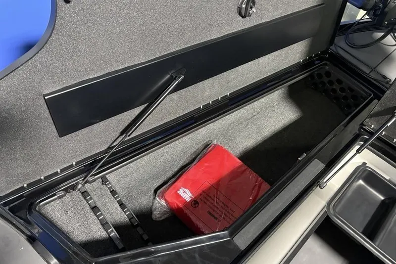Slide: The Image of Open storage compartment in 2026 Nitro Z20 XL Pro boat, featuring a red safety kit. - 12