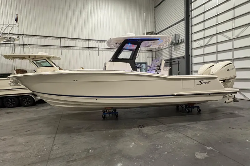 Slide: The Image of 2026 Scout 288 LXF boat in indoor storage, side view. - 1