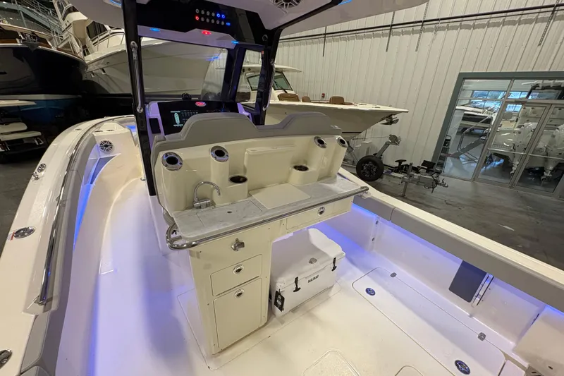 Slide: The Image of 2026 Scout 288 LXF boat interior with modern helm and seating in a showroom. - 11