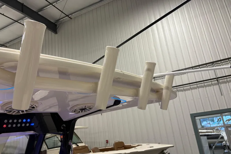 Slide: The Image of 2026 Scout 288 LXF boat interior with rod holders and speakers in a showroom. - 18