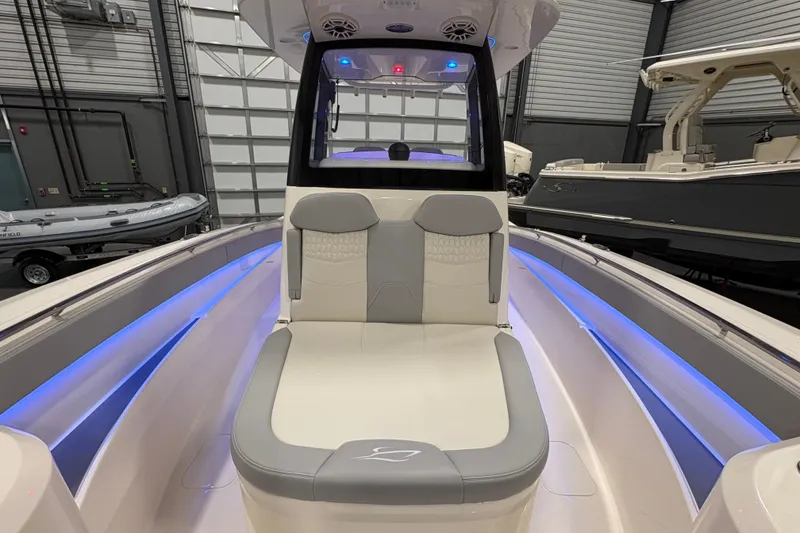 Slide: The Image of 2026 Scout 288 LXF boat interior with blue LED lighting and cushioned seating. - 19