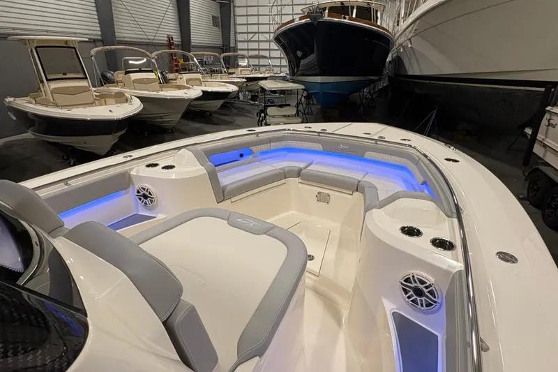 Slide: The Image of 2026 Scout 288 LXF boat interior with blue LED lighting in a showroom. - 21