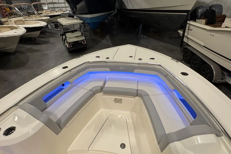 Slide: The Image of 2026 Scout 288 LXF boat interior with blue LED lighting and cushioned seating. - 22