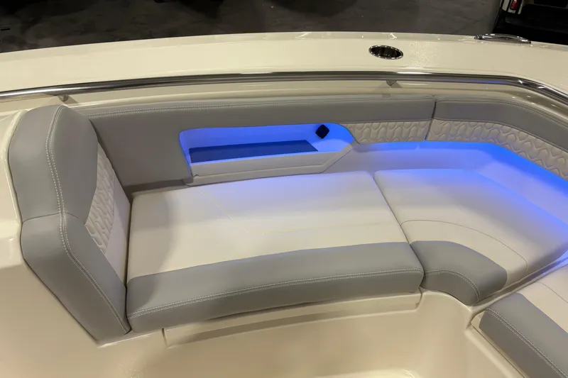 Slide: The Image of 2026 Scout 288 LXF boat interior with cushioned seating and ambient blue lighting. - 23