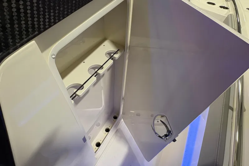 Slide: The Image of Open storage compartment on 2026 Scout 288 LXF boat, featuring cup holders and sleek design. - 25