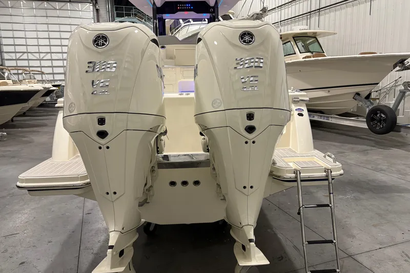 Slide: The Image of 2026 Scout 288 LXF boat with dual outboard engines in a showroom. - 5