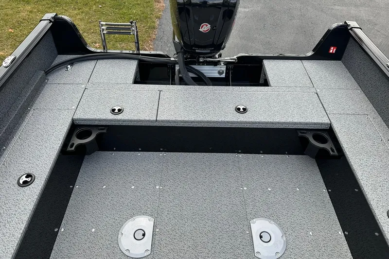 Slide: The Image of 2026 Lund 1800 Explorer SS boat interior with gray textured flooring and motor. - 10
