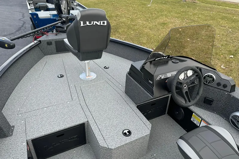 Slide: The Image of 2026 Lund 1800 Explorer SS boat interior with steering wheel and seating. - 14