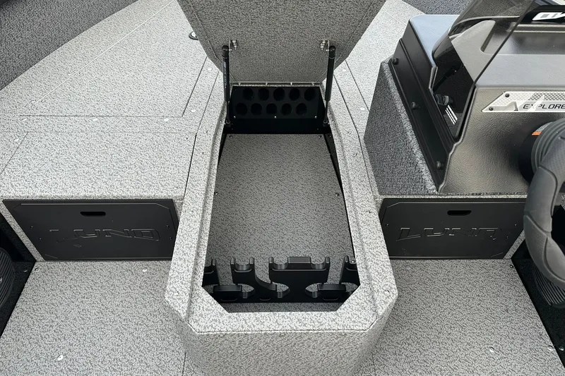 Slide: The Image of 2026 Lund 1800 Explorer SS boat interior with open storage compartment and textured flooring. - 15