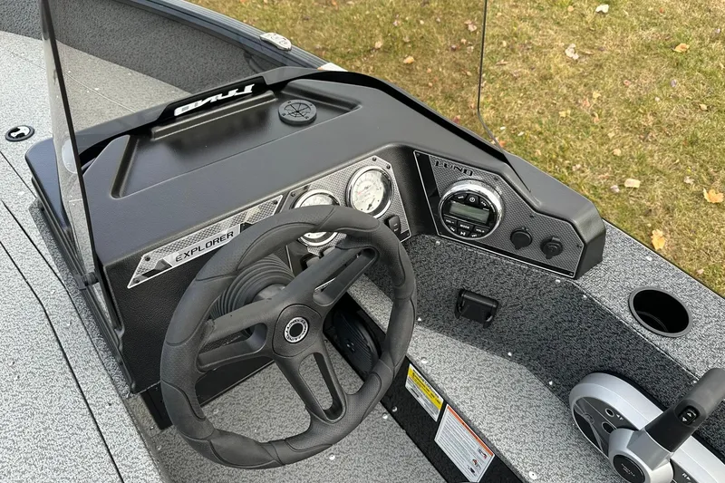 Slide: The Image of 2026 Lund 1800 Explorer SS boat dashboard with steering wheel and control panel. - 16