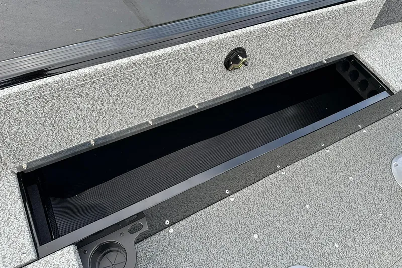 Slide: The Image of 2026 Lund 1800 Explorer SS boat storage compartment, open and empty, with textured surface. - 22