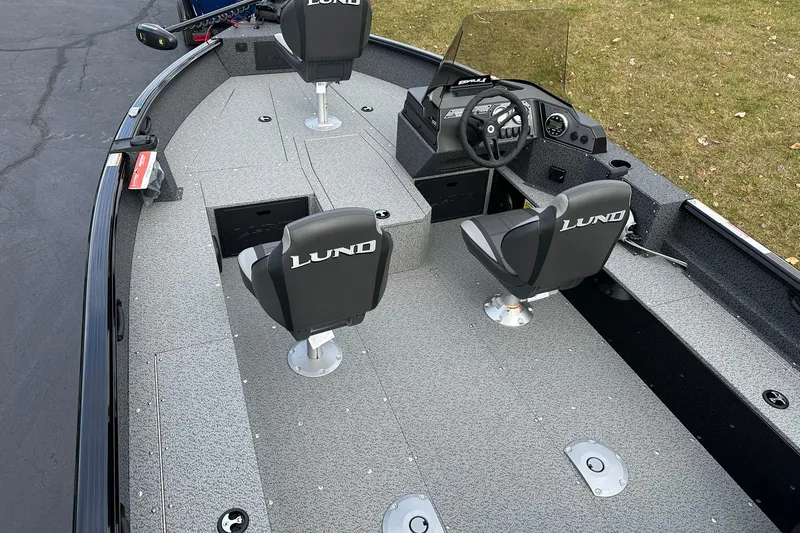 Slide: The Image of 2026 Lund 1800 Explorer SS boat interior with steering console and seating. - 7